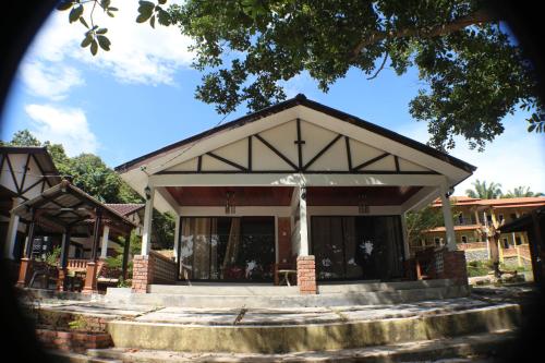 a house with a porch with a roof at Umang-umang Chalet in Kampong Tanjong Dahan