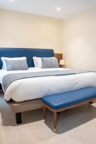 a large bed with a blue headboard and a blue bench at Résidence Aston la Scala in Nice