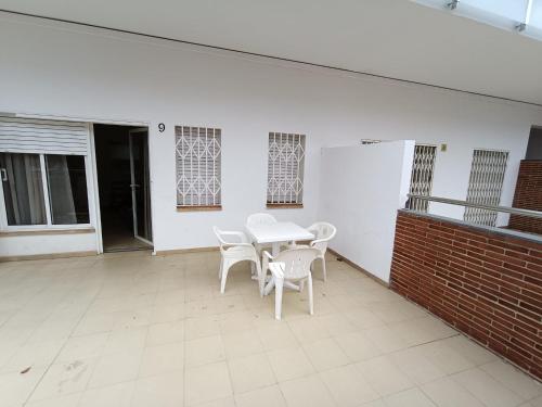 a white table and chairs on a patio at APCOSTAS Els Pins Lotus in Blanes