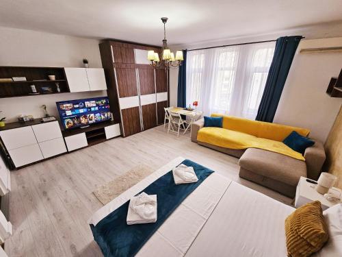 a living room with a couch and a tv at Lovely Studio in Downtown Bucharest in Bucharest