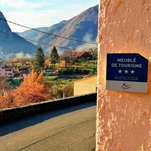 un panneau sur le côté d'une route avec une montagne dans l'établissement Mon gîte à Pélasque, à Lantosque