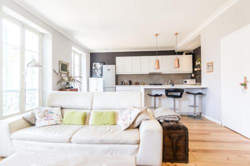 un salon avec un canapé blanc et une cuisine dans l'établissement Blue appart - centre ville - gare, à Nice
