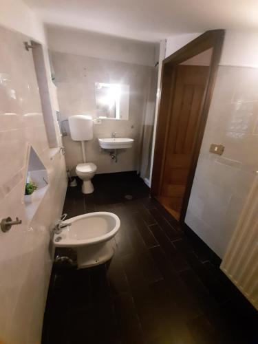 a bathroom with a toilet and a sink and a mirror at villamuna in Ferentillo