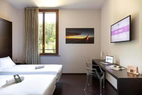 a hotel room with two beds and a desk at B&B HOTEL Malpensa Lago Maggiore in Vergiate