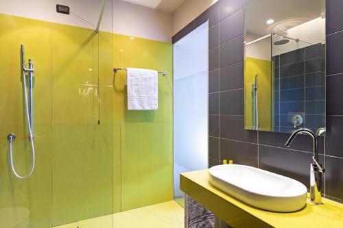 a bathroom with a glass shower and a sink at B&B HOTEL Malpensa Lago Maggiore in Vergiate