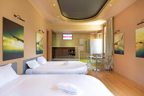 a hotel room with two beds and a tv at B&B HOTEL Malpensa Lago Maggiore in Vergiate