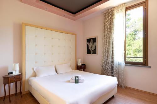 a bedroom with a large white bed and a window at B&B HOTEL Malpensa Lago Maggiore in Vergiate