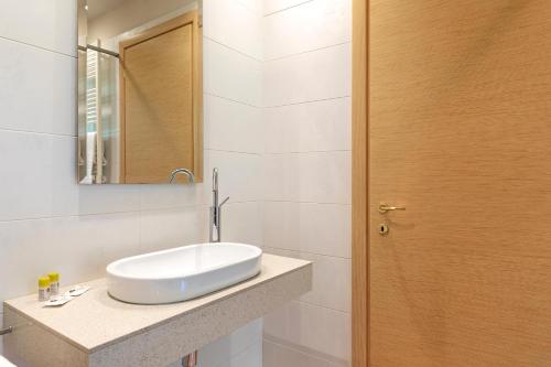 a bathroom with a white sink and a mirror at B&B HOTEL Malpensa Lago Maggiore in Vergiate