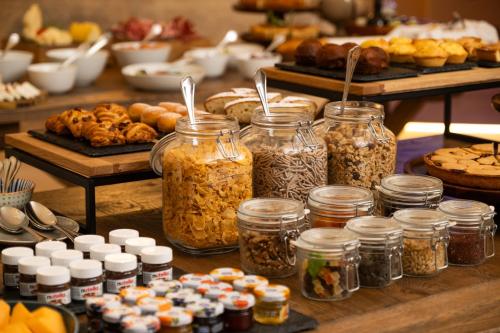 a table filled with jars of food and pastries at Masseria Donna Menga - The Leading Hotels of the World in Torre Lapillo