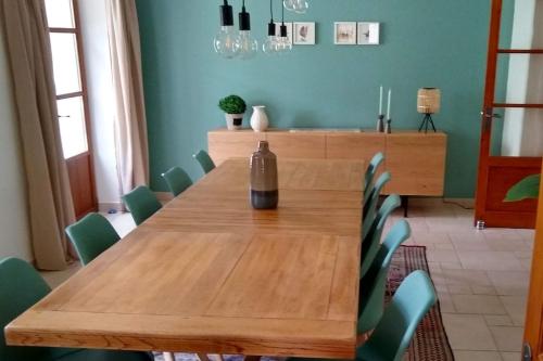 - une table en bois dans une chambre avec des chaises vertes dans l'établissement Gamel, à Villeneuve-sur-Lot