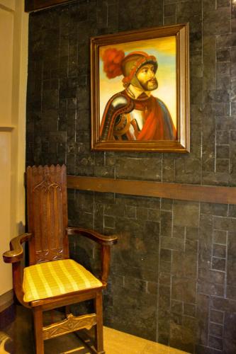 a painting of a man on a wall next to a chair at Castillo Medieval in Viña del Mar