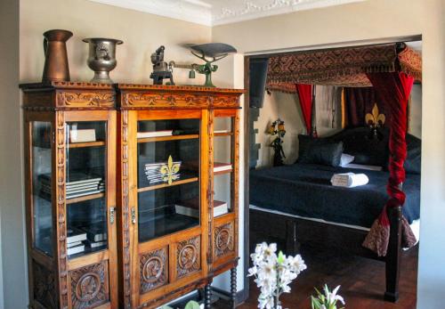 a bedroom with a wooden cabinet next to a bed at Castillo Medieval in Viña del Mar