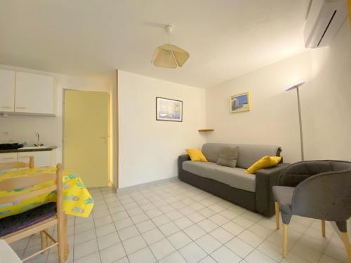 un salon avec un canapé et une table dans l'établissement Sol-y-Days Mathilde, Agréable appartement en rez-de-jardin avec parking et un accès direct à la plage, au Grau-du-Roi