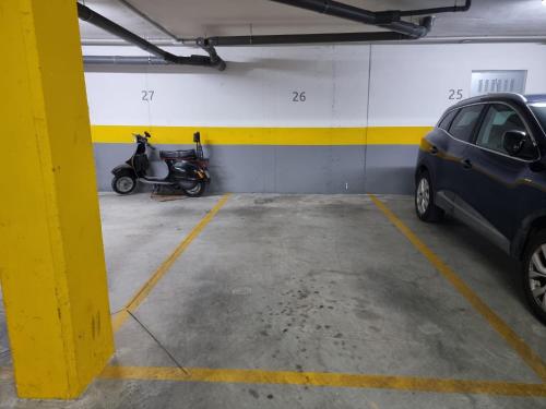 a parking garage with a motorcycle and a car in it at Residencial Costa Doñana (Sanlucar de Barrameda) in Sanlúcar de Barrameda