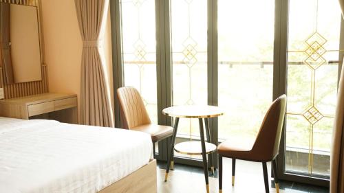 a bedroom with a bed and a table and chairs at Trung Đông Hotel in Can Tho