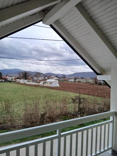 a view of a field from a porch with a fence at Apartman Eni in Sarajevo