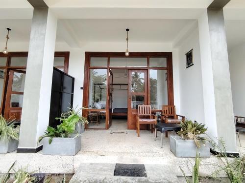 a living room with a large sliding glass door at Surfing Pinthaliya - Midigama in Weligama