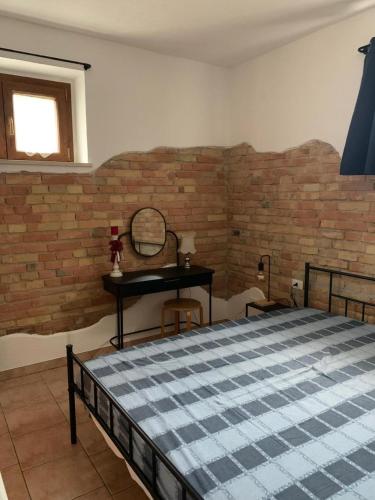 a bedroom with a bed and a brick wall at La stalla di nonno Zopito casa vacanze in Loreto Aprutino