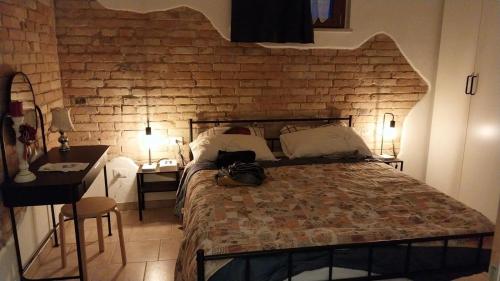 a bedroom with a large bed and a brick wall at La stalla di nonno Zopito casa vacanze in Loreto Aprutino