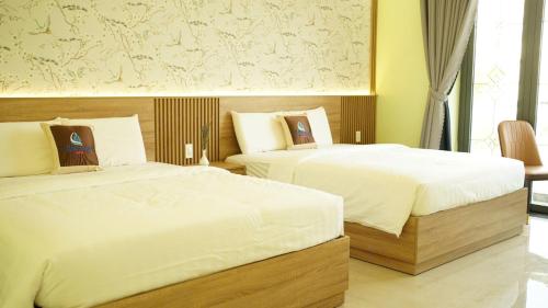 a bedroom with two beds and a window at Trung Đông Hotel in Can Tho