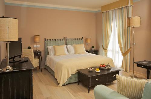 ein Schlafzimmer mit einem Bett, einer Couch und einem Tisch in der Unterkunft Albergo La Fontanella in San Casciano dei Bagni