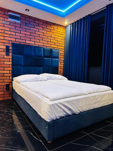 a bed in a room with a brick wall at Apartament Red in Sarbinowo