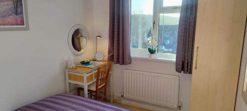 a bedroom with a bed and a table and a window at Ludlow Mews Town House with Free parking in Ludlow
