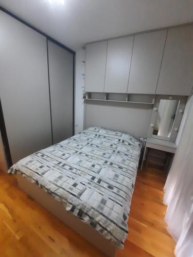 a bed in a room with white cabinets at Podgorica Zabjelo titex 3 in Podgorica