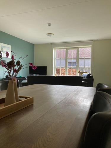 a living room with a large wooden table and chairs at Accommodatie in herbouwde boerenschuur Koestal in Retranchement