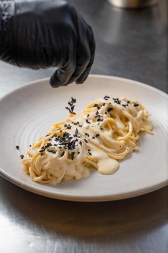 a plate of pasta with black sprinkles on top of it at Hotel Il Castagno in Mugena