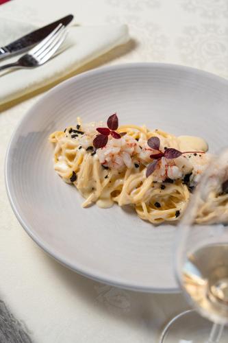 a plate of pasta with seafood on a table at Hotel Il Castagno in Mugena