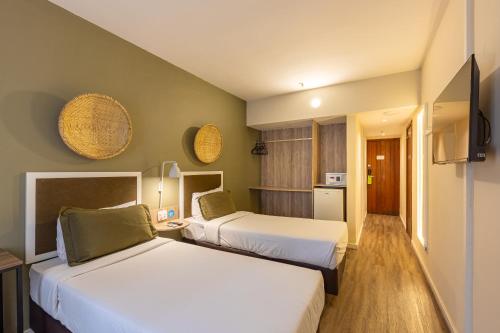 a hotel room with two beds and a kitchen at B&B HOTEL Rio Copacabana Posto 5 in Rio de Janeiro