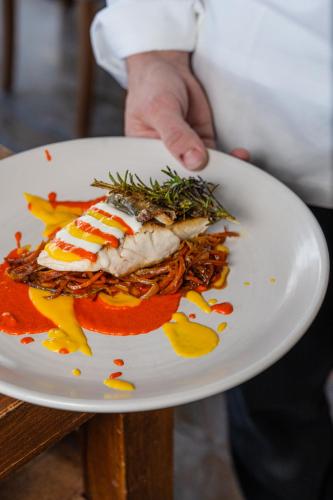 a person holding a plate of food on a table at Hotel Il Castagno in Mugena