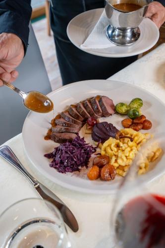 a plate of food with meat and vegetables on a table at Hotel Il Castagno in Mugena