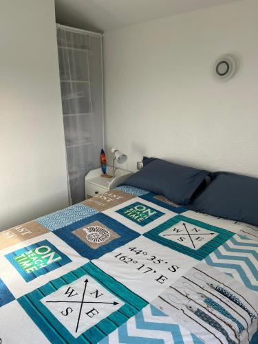 une chambre avec un lit avec une couette dessus dans l'établissement Jolie petite maison plein sud, à Saint Cyprien Plage