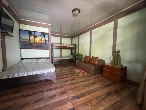 a bedroom with a bed and a couch in it at Villas Ela en Bahía Ballena,Uvita Hermosas habitaciones privadas grandes, piscina, cocina, jacuzzi, aire acondicionado, tv y baño privado in Uvita