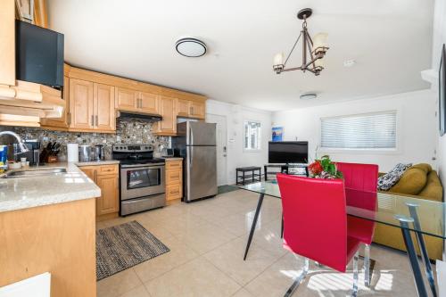 a kitchen with a table and red chairs in it at Spacious and Modern Comfort Retreat in Heart of Vancouver in Vancouver
