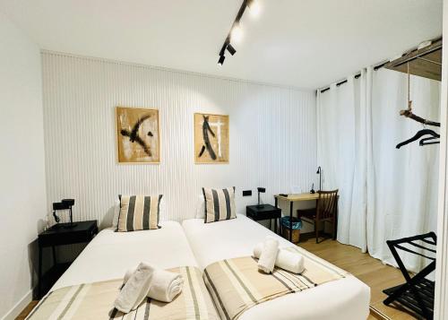 una camera da letto bianca con due letti e una scrivania di Autentic Boutique Moncloa a Madrid