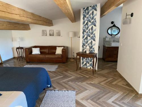 un salon avec un lit et un canapé dans l'établissement La Maison de Léo, à Saint-Mitre-les-Remparts
