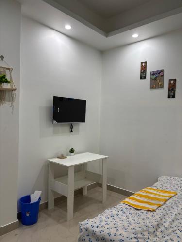 a white room with a table and a tv on a wall at Jassy haven in Guwahati