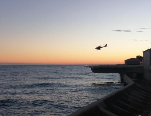 a plane flying over the ocean at sunset at Résidence Cap Winston in Cap d'Ail