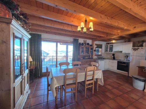 une cuisine et une salle à manger avec une table et des chaises dans l'établissement Chalet Cent Names - 8 pers - St Foy Station, à Sainte-Foy-Tarentaise