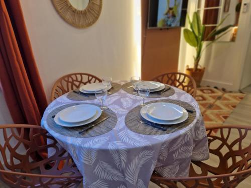 une table avec des assiettes et des verres à vin dessus dans l'établissement Roquebrune : Appartement 4 personnes proche de la plage (AV), à Roquebrune-Cap-Martin