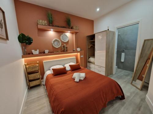 - une chambre avec un grand lit orange et une salle de bains dans l'établissement Roquebrune : Appartement 4 personnes proche de la plage (AV), à Roquebrune-Cap-Martin