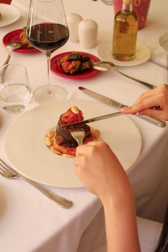 a person cutting a plate of food on a table at Riad Fes - Relais & Châteaux in Fès