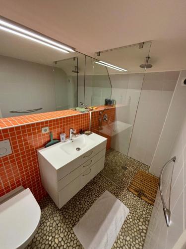 une salle de bain avec un lavabo, des toilettes et un miroir dans l'établissement Maison - Les Embruns - Vue mer, à Cancale