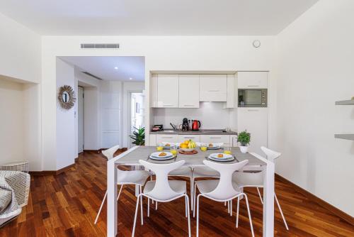 une cuisine et une salle à manger avec une table et des chaises dans l'établissement Palais de la Rose-centre-clim-plage, à Menton