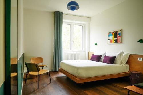 un dormitorio con una cama y una ventana en Numa Milan Sempione, en Milán
