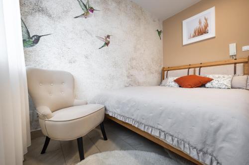 トルナヴァにあるCosy Apartment, Near Downtown, Self Check-inのベッドルーム1室(ベッド1台、椅子、壁に鳥付)