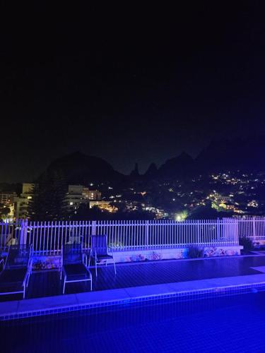 a group of chairs sitting on a balcony at night at Serra Loft Premium in Teresópolis